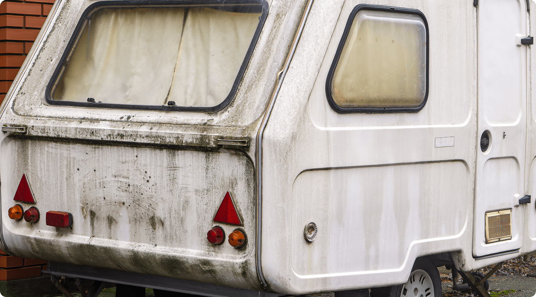 Weathered white camper parked outdoors